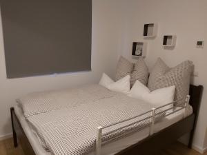 a bed with white pillows in a bedroom at Ecki's Ferienhaus "KOMM an de BÄK" mit 5 Sternen bewertet bei Google und Traumferienwohnungen in Alt Schönau