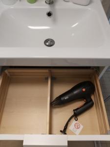 a black hairdryer in a drawer under a sink at Ecki's Ferienhaus "KOMM an de BÄK" mit 5 Sternen bewertet bei Google und Traumferienwohnungen in Alt Schönau