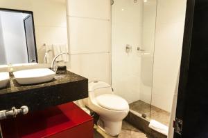 a bathroom with a toilet and a sink and a shower at Hotel Bogota Virrey in Bogotá