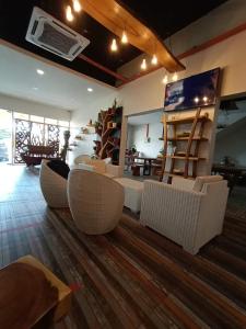 a living room with white chairs and a table at The Serai Cottage Downtown Hotel in Kuala Terengganu