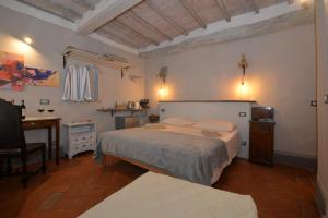a bedroom with a bed and a desk and a computer at La Rughetta Guest House in Montepulciano