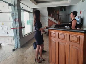 two women standing at a counter in a kitchen at JC Palace Hotel in Machado