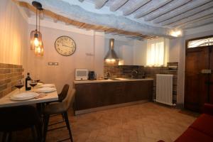 cocina con mesa y reloj en la pared en La Rughetta Guest House, en Montepulciano