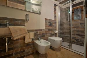 La salle de bains est pourvue de toilettes, d'un lavabo et d'une douche. dans l'établissement La Rughetta Guest House, à Montepulciano