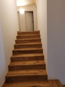 una escalera en una casa con suelos de madera en Ferienwohnungen Alvino, en Friedrichshafen