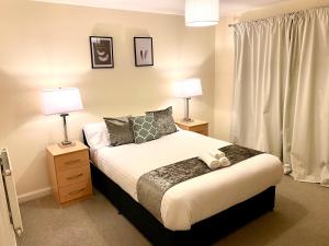 a bedroom with a bed with two lamps and a window at Superior Two-Bed Apartment with Free Parking, CV1 Coventry in Coventry