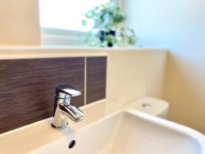 a bathroom sink with a faucet and a mirror at Superior Two-Bed Apartment with Free Parking, CV1 Coventry in Coventry +11 photos