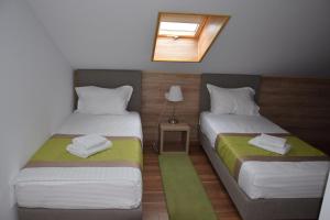 two beds in a small room with a window at Crema Residence in Alba Iulia