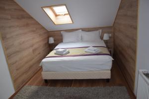 1 dormitorio pequeño con 1 cama con tragaluz en Crema Residence en Alba Iulia