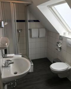La salle de bains est pourvue d'un lavabo et de toilettes. dans l'établissement Pension Da Enzo, à Otterbach