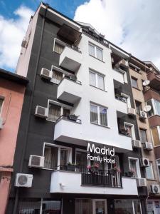 un grande edificio bianco con un cartello sopra di Family Hotel Madrid a Sofia