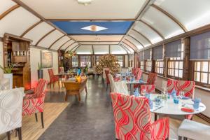 a restaurant with red and white tables and chairs at Logis Hôtel La Commanderie de Champarey in Bourgoin