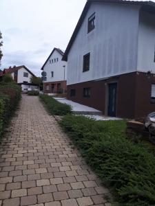 un camino de ladrillo junto a un edificio blanco en Lavendel Apartment en Riederich