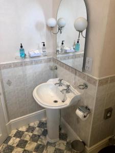 a bathroom with a sink and a mirror at Rushpool Hall in Saltburn-by-the-Sea