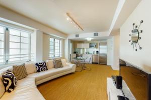 een woonkamer met een witte bank en een keuken bij The Carlyle 3G in Miami Beach