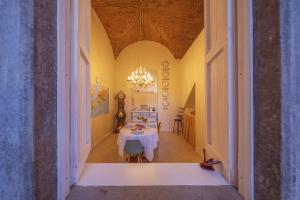 una sala da pranzo con tavolo e lampadario pendente di Bergamo Bella B&B a Bergamo