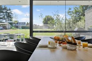 赫林貝亨的住宿－BnB Manere，餐桌,早餐包括面包和橙汁