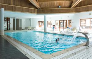 a swimming pool with people in the water at Résidence Odalys L'Orée des Pistes in Saint-Sorlin-dʼArves