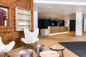 a lobby with white chairs and tables and a counter at Résidence Odalys L'Orée des Pistes in Saint-Sorlin-dʼArves
