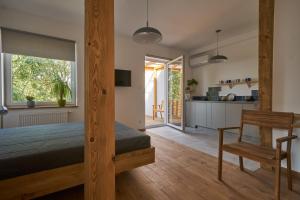 a bedroom with a large bed and a kitchen at Apartamenty Ponidzie in Busko-Zdrój