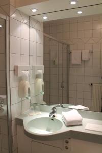 a bathroom with a sink and a large mirror at Hotel Wörth in Wörth an der Isar