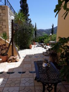 eine Terrasse mit einem Tisch, Stühlen und Pflanzen in der Unterkunft Sivas Apartments-Studios,Sigelakis with very nice view in Sívas