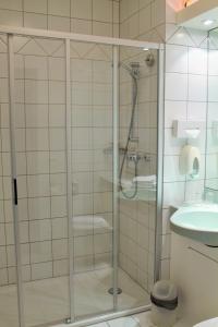 a glass shower in a bathroom with a sink at Hotel Wörth in Wörth an der Isar