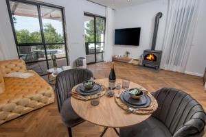 a living room with a table and chairs and a fireplace at Alonella in Kefar Weradim