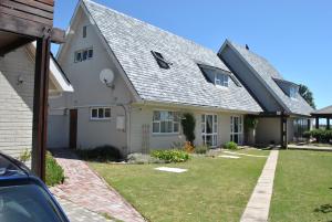 a white house with a gray roof at Cotswold House Residence in Cape Town
