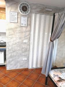 a room with a curtain and a clock on a wall at Vila Violeta in &Scaron;abac