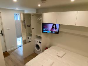 a bedroom with a bed with a tv on the wall at Stylish house in the heart of Breda city center in Breda