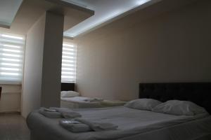 1 dormitorio con 2 camas y ventana en Hotel Abro Necatibey, en Ankara