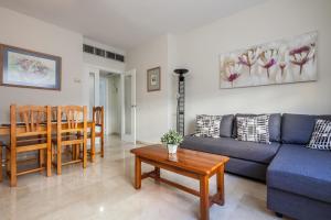 - un salon avec un canapé bleu et une table dans l'établissement Apartamento cerca del Alcázar con garaje privado, à Séville