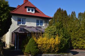 una casa con techo rojo y algunos arbustos en Am Klostergarten, en Heilbad Heiligenstadt