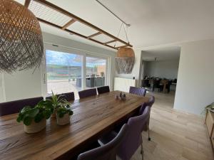 a dining room with a large wooden table and chairs at Den 118, aan de Maas in Maasmechelen