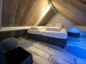a bedroom with a bed in a attic at Den 118, aan de Maas in Maasmechelen