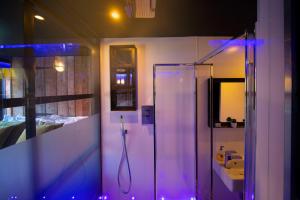 y baño con ducha con luces moradas. en Briggate Hotel en Leeds