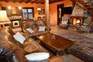 a living room with a leather couch and a table at Moiata Kashta Villa in Popovi Livadi