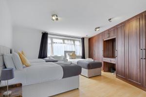 1 dormitorio con 2 camas y TV. en Heathrow Living St Annes Serviced House 5 bedrooms 3 bath By 360Stays, en Stanwell