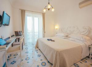 a bedroom with a bed and a desk and a television at Grand Hotel Le Rocce in Gaeta
