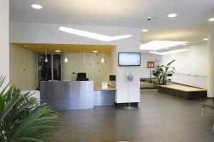 an office lobby with a reception desk and potted plants at Actif Residence in La Grande Motte