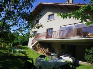a house with tables and chairs in the yard at Gîte st Julien des collines in Le Grand Serre