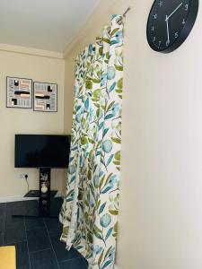 una habitación con una cortina con un reloj en la pared en Pine Lodge en Gillingham