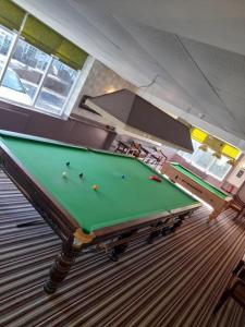a room with a pool table in a room withwindows at The Avenue Club and Lodge in Birmingham