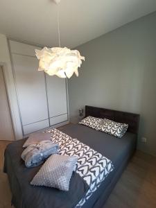 1 dormitorio con 2 camas y lámpara de araña en Apartamenty Września, en Września