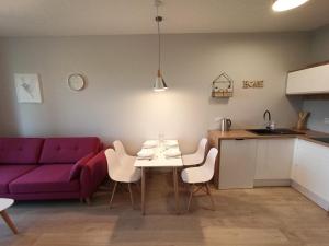 a living room with a purple couch and a table and chairs at Apartamenty Września in Września