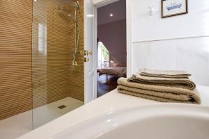 a bathroom with a tub and a glass shower at Villa Antumalal B&B in Málaga