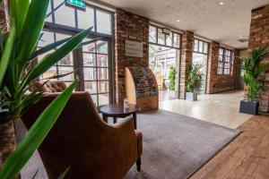 um lobby com um sofá e uma mesa e algumas plantas em Dragonfly Hotel Bury St Edmunds em Bury Saint Edmunds