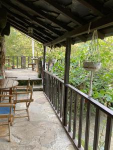 une véranda avec une table, des chaises et un lustre dans l'établissement Quinta da Recochina, à Castro Daire