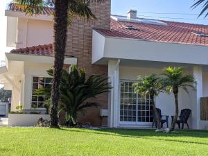 een huis met palmbomen ervoor bij The Palm House in Ovar